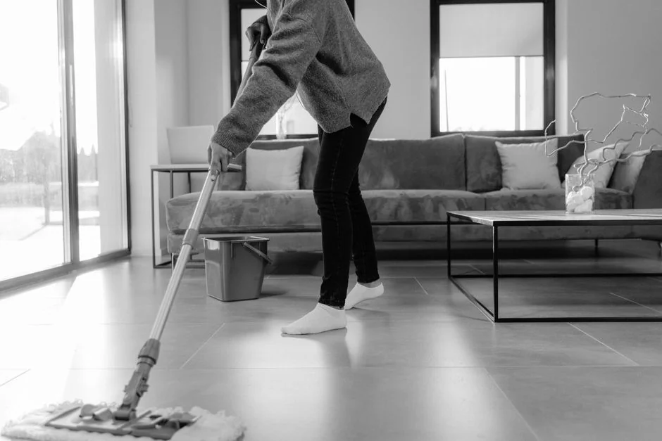 about-us-01 Person using spray bottle and cloth for cleaning a kitchen shelf, ensuring hygiene and cleanliness.